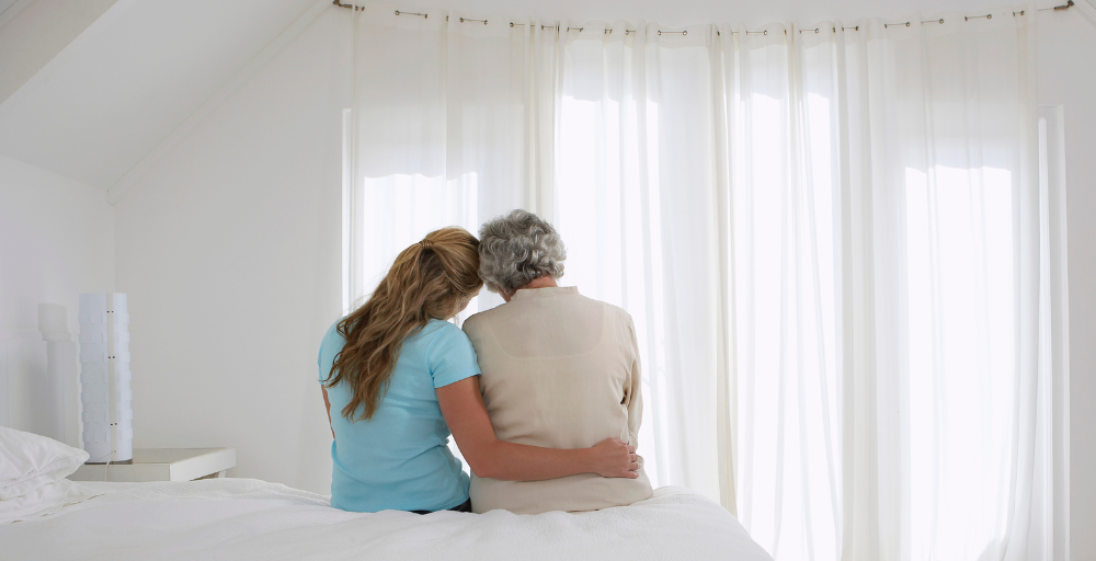 A family caregiver hugs her loved one and is better able to enjoy her time with her after taking a break by using respite care services.
