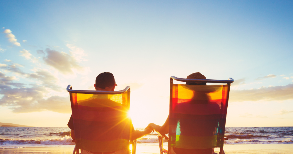 Caregiver travel hacks can help couples like this one on the beach enjoy their vacation.