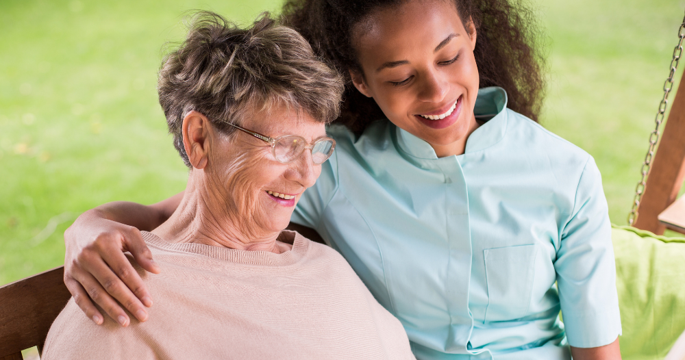 Professional caregivers like this one who is reading a book with a senior client can help them stay mentally active and engaged.