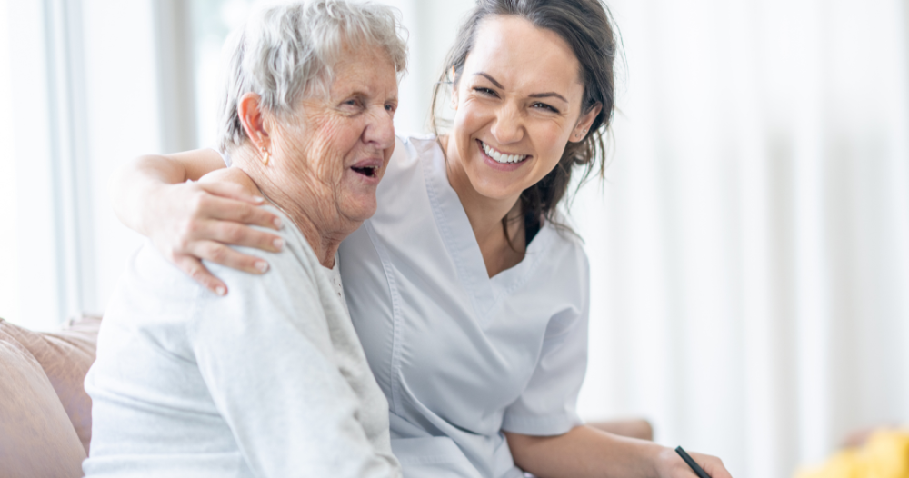 A professional caregiver embraces a senior client, showing the level of trust and comfort between them.