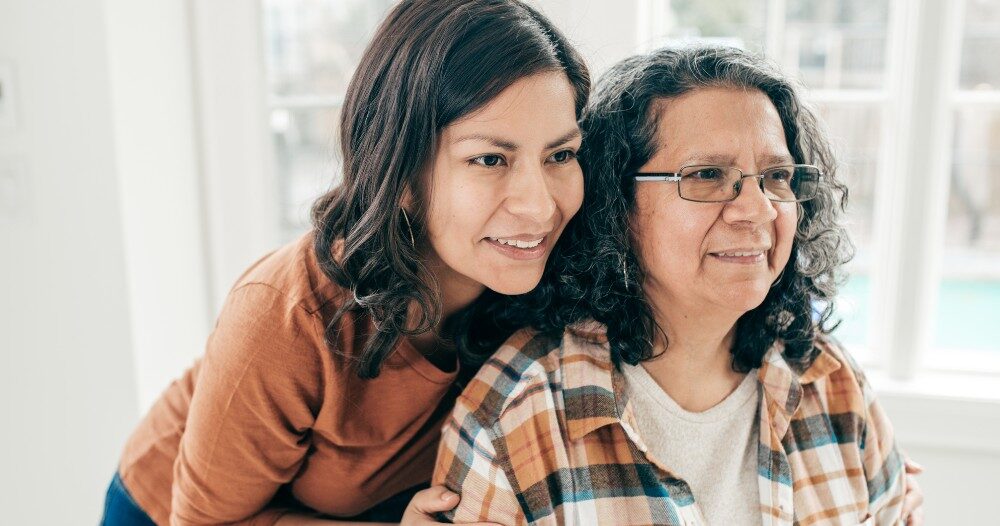 A woman hugs her older mother, representing compassionate senior care