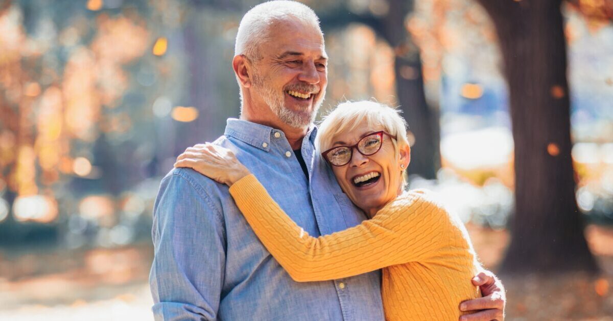An older couple enjoys being outside in the fall, representing the idea of different fall activities for seniors.
