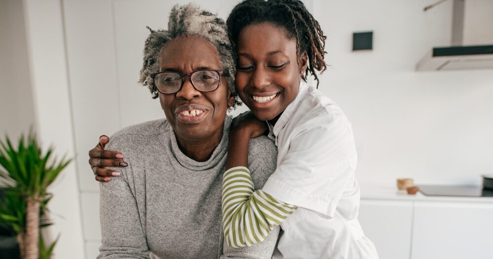 A caregiver hugs a client, representing the science of caregiving and how latest research can help provide quality care.