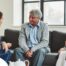 A caregiver talks with an elderly couple representing the kind of communication that professional caregivers need to have to anticipate client needs.
