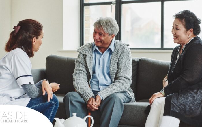 A caregiver talks with an elderly couple representing the kind of communication that professional caregivers need to have to anticipate client needs.