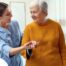 A caregiver helps a client get around, demonstrating one of the job duties of a caregiver.