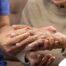 A care provider examines an older adult’s fingers, representing what would happen in an examination for rheumatoid arthritis.